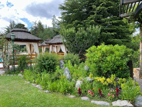 a garden with two gazebos and flowers at El Carmelo Mountain Lodge in Potrerillos
