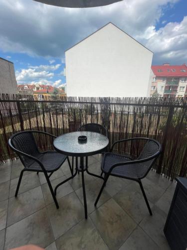 een patio met 2 stoelen en een tafel op een balkon bij Giallo-Rosso in Białystok