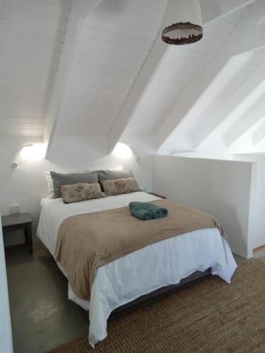a bedroom with a large bed in a white room at Spacious loft in Paternoster