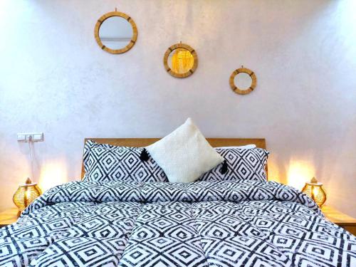 a bedroom with a bed with pillows and mirrors on the wall at Welcome Home El Jadida in El Jadida