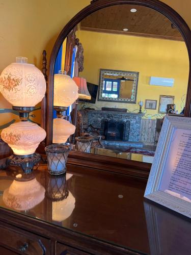 a vanity with a mirror and a desk with a lamp at The Russ House in Tombstone