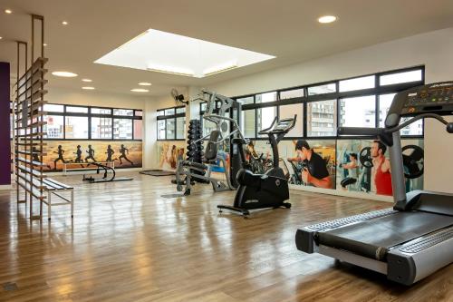 a gym with treadmills and ellipticals in a building at Mercure Curitiba 7 de Setembro in Curitiba