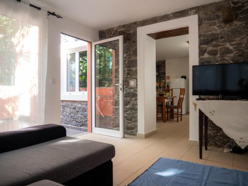 a living room with a fireplace and a tv at Casa dos Anjos in Ponta do Sol