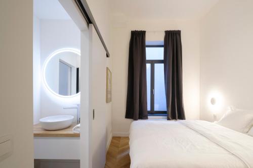 a bedroom with a bed and a sink and a window at The Duke flats - 1 bedroom apartments Grand Place in Brussels