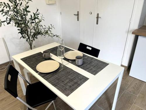 uma mesa branca com dois pratos por cima em Appartement proche tramway em Vitry-sur-Seine