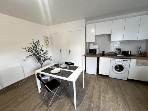 a kitchen with a white table and a kitchen with a washing machine at Appartement proche tramway in Vitry-sur-Seine