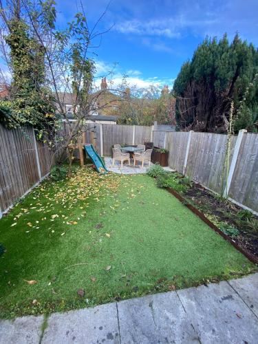 a backyard with a picnic table and a fence at Stunning 4BD House wLarge Garden - Finsbury Park! in London