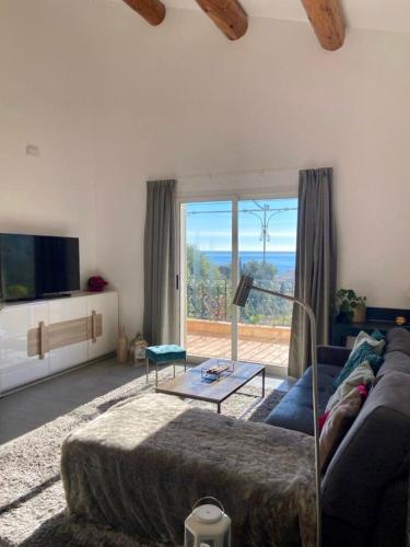 un salon avec un canapé et une grande fenêtre dans l'établissement Villa à Menton avec vue mer, à Menton