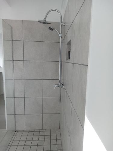 a shower in a bathroom with a tile wall at Spacious loft in Paternoster