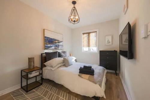 a bedroom with a bed and a television and a chandelier at Casa Hotels in Toronto