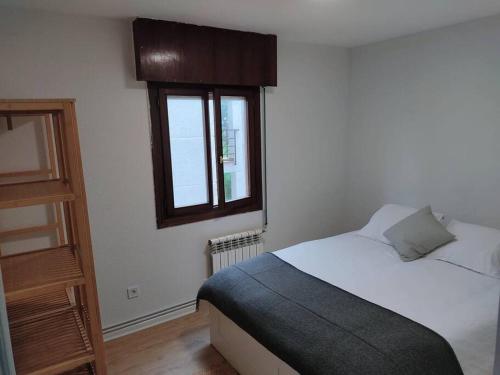 a bedroom with a bed and a window at Apartamento en Mogro. in Mogro