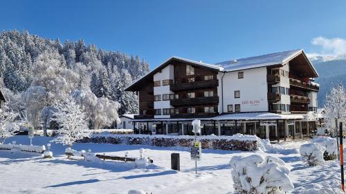 a large building in the snow with snow covered trees at Das Alpin - Hotel Garni Guesthouse in Scheffau am Wilden Kaiser