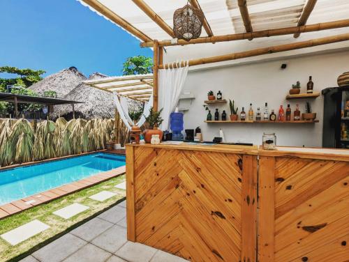 a kitchen with a wooden bar and a swimming pool at Wander Boutique Hotel in El Paredón Buena Vista