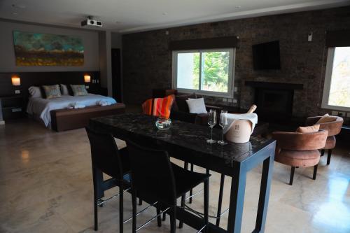 a living room with a table and a bedroom at El Carmelo Mountain Lodge in Potrerillos