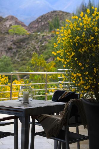a table and chairs sitting on a patio with flowers at El Carmelo Mountain Lodge in Potrerillos
