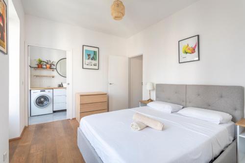 a white bedroom with a bed and a washing machine at Calme, soleil, plage - Catalans in Marseille