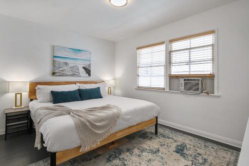 a white bedroom with a bed and two windows at Quaint 1BD/1BA Bungalow- Venice Beach in Los Angeles