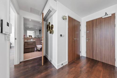 a room with a hallway with a door and a bathroom at Brand new apartment 20 mins from London Waterloo BP34 in London