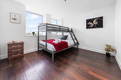 a bedroom with a bunk bed and a wooden floor at Brand new apartment 20 mins from London Waterloo BP34 in London
