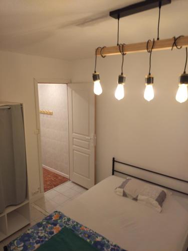 een slaapkamer met een bed met verlichting aan het plafond bij T4 Prado vélodrome plage 3 chambres in Marseille