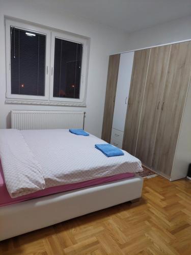 een slaapkamer met een bed met blauwe handdoeken bij Smjestaj_S in Bijeljina