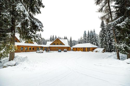 a lodge in the snow with snow covered trees at Rezort pri Jazere Podbanské in Vysoké Tatry