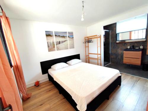 1 dormitorio con 1 cama en una habitación en La Maison Bleue, en Urville-Nacqueville