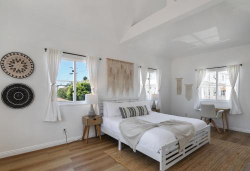 a white bedroom with a white bed and windows at Exclusive 2BD 3BA with Balcony Venice Beach in Los Angeles