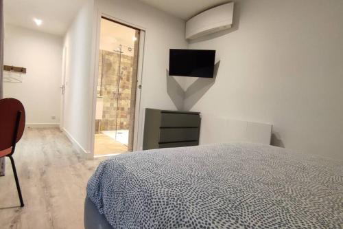 - une chambre avec un lit et une télévision murale dans l'établissement Studio sur patio au coeur des Chartrons, à Bordeaux