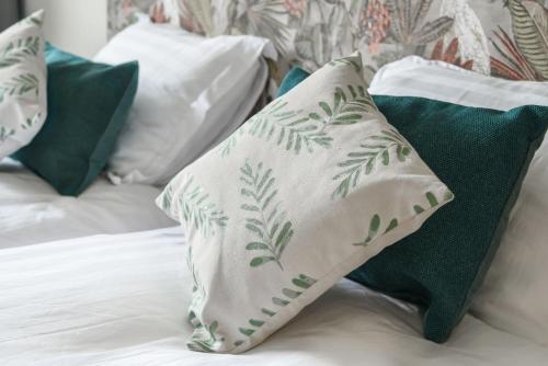 a group of pillows sitting on top of a bed at Luxe bosvilla De Paradijsvogel in Rijs