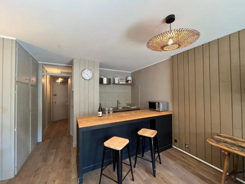 une cuisine avec un comptoir et deux tabourets dans l'établissement Studio lumineux à Pra-Loup, proche pistes et commerces, avec parking privé et box à ski - FR-1-165A-186, à Uvernet