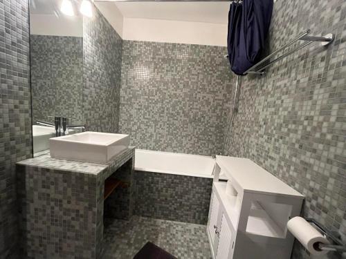 une salle de bain avec un lavabo et une baignoire dans l'établissement Studio lumineux à Pra-Loup, proche pistes et commerces, avec parking privé et box à ski - FR-1-165A-186, à Uvernet