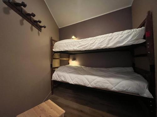 une chambre avec deux lits superposés avec des draps blancs dans l'établissement Studio lumineux à Pra-Loup, proche pistes et commerces, avec parking privé et box à ski - FR-1-165A-186, à Uvernet