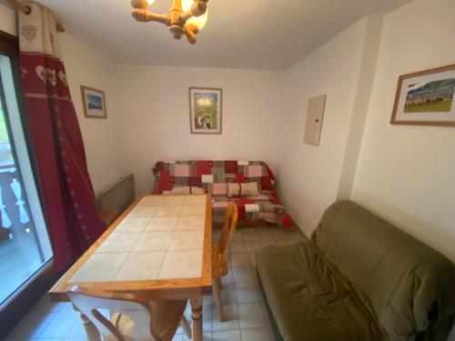 un salon avec une table et un canapé dans l'établissement Studio à 750m du Domaine Skiable du Linga avec Balcon et Parking Privé - FR-1-693-106, à Châtel