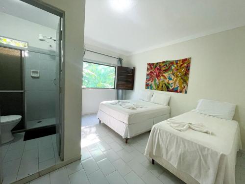 Habitación con 2 camas, baño y ducha. en Pousada Voo da Águia, en Itacaré