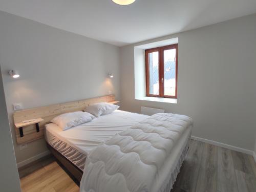 1 dormitorio con 1 cama blanca grande y ventana en Appartement Autrans, 4 pièces, 6 personnes - FR-1-737-79, en Autrans