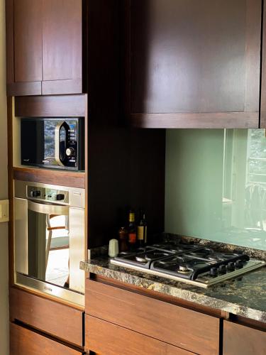 a kitchen with a stove and a microwave at El Carmelo Mountain Lodge in Potrerillos