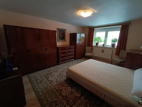 a bedroom with a bed and a dresser and a window at 3 pokoje v rodinném domě, sdílená kuchyně s hostitelkou (homestay) in Samotíšky