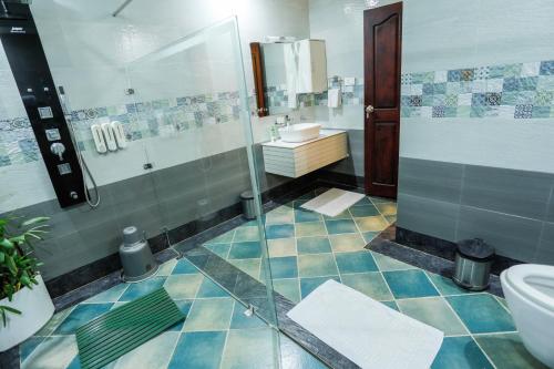 a bathroom with a shower and a sink and a toilet at Neelambari Ecotoursm in Trichūr