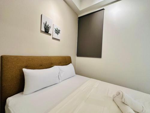a small bedroom with a bed with white sheets at Urban Suite Cozy Family Homestay at Georgetown by URBAN STAYCATION HENG LOD in Jelutong