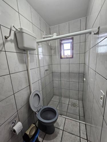 uma casa de banho com um WC e um chuveiro com uma janela em Pousada Recanto das Ondas em Garopaba