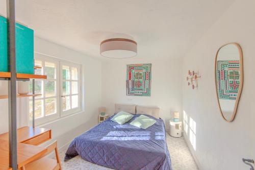een slaapkamer met een bed en een spiegel aan de muur bij Villa Paloma - nature meets design in Tourrettes-sur-Loup