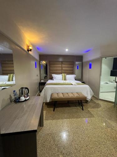 a large bedroom with a large bed and a table at Ikeja Airport View in Lagos