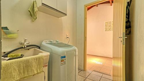 a small bathroom with a sink and a tub at #018 Casa 2 minutos a pé da Praia de Palmas in Governador Celso Ramos