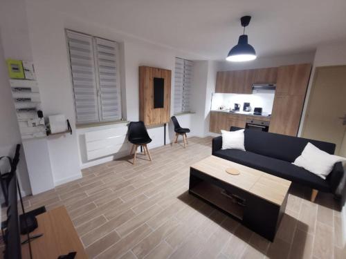 a living room with a blue couch and a kitchen at La Monaco du Nord in Granville
