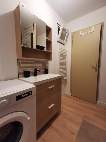 a laundry room with a washing machine and a door at La Monaco du Nord in Granville