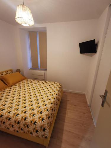 a small bedroom with a bed and a television at La Monaco du Nord in Granville