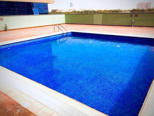 a large swimming pool on top of a building at Cozy and Spacious Studio in Dubai