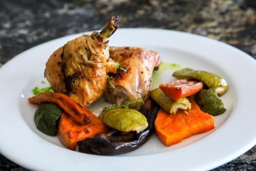 a plate of food with chicken and vegetables on a table at El Carmelo Mountain Lodge in Potrerillos
