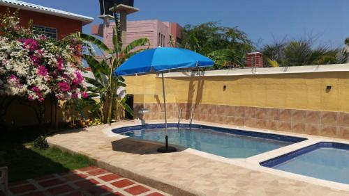 un parasol bleu assis à côté d'une piscine dans l'établissement Casa hostal Rochymar, 